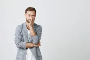 exhausted-young-businessman-rub-eye-feeling-tired-300x200