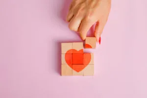 relationship-concept-flat-lay-finger-pulling-out-wooden-block-300x200