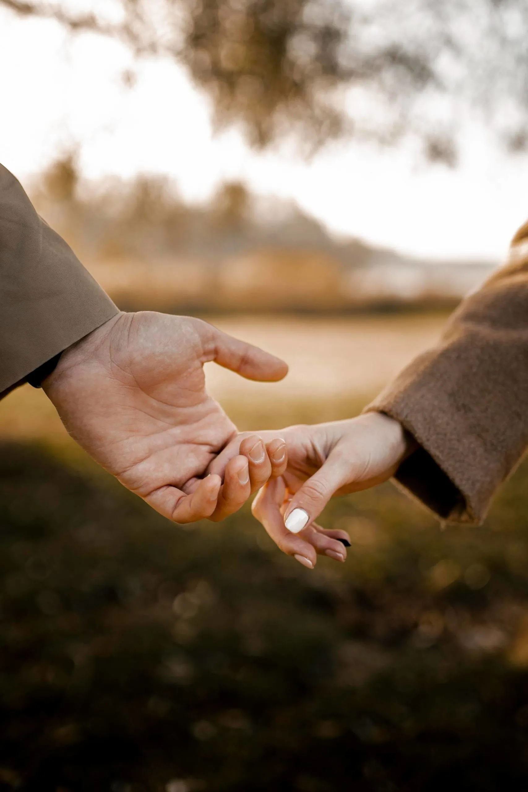 close-up-couple-holding-hands-outside-scaled