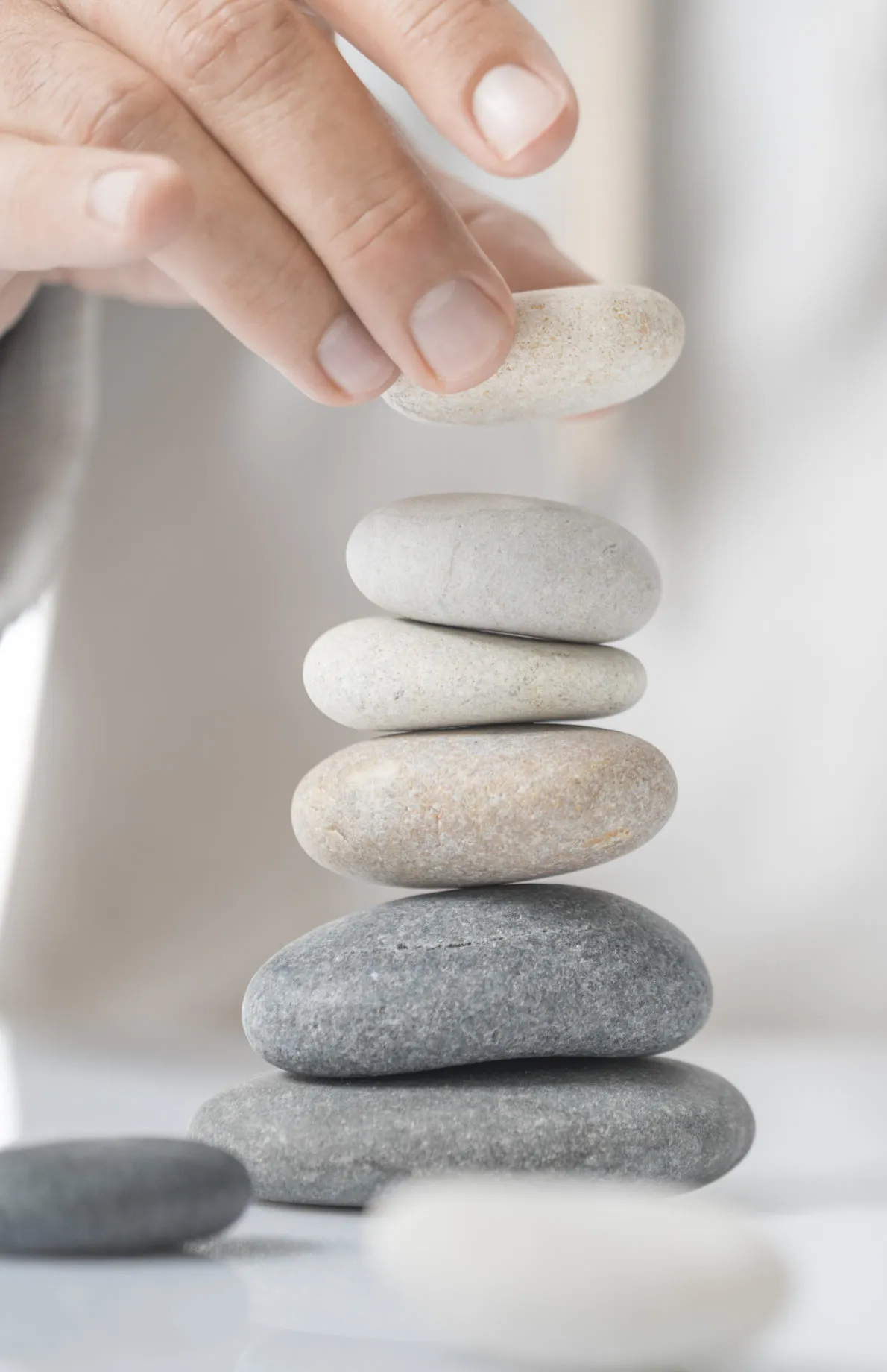 man-stacking-pebbles-on-a-table-with-copy-space-concept-of-personal-development-self-realization-scaled