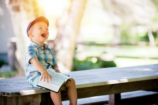 Emotionale Abhängigkeit Zeichen, wenn das innere Kind zu früh erwachsen wurde. Kleiner Junge liest Buch.