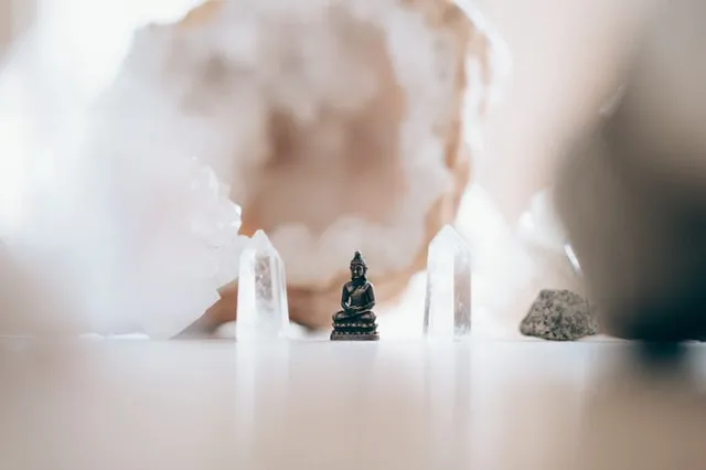 Bild zeigt Buddha meditierend zwischen Kristallen. Symbol für Samadhi / Erleuchtung durch Meditation