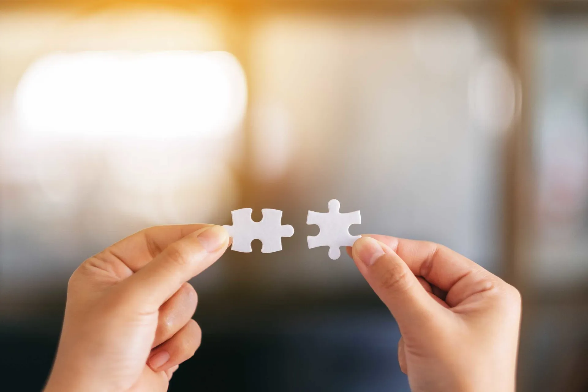 closeup-image-two-hands-holding-putting-piece-white-jigsaw-puzzle-together-scaled