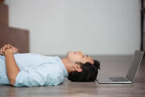 asian-man-lying-on-floor-at-his-laptop-300x200