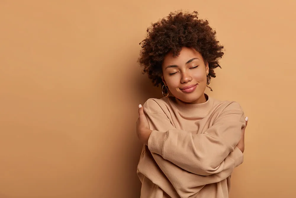 love-yourself-self-acceptance-gentle-lovely-afro-american-woman-crosses-hands-and-embraces-own-body-tilts-head-and-closes-eyes
