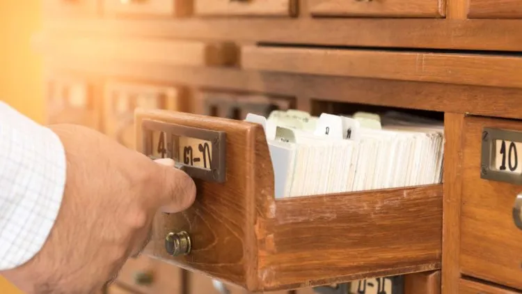 a-man-opens-wooden-cabinet-stored-library-index-1-750x422